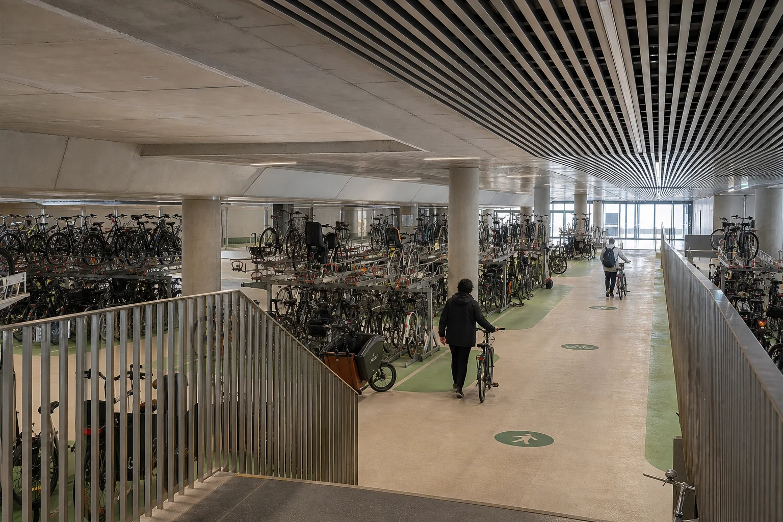 Projection d'un grand parking vélo intérieur avec racks double étage, vélos cargos et allée centrale