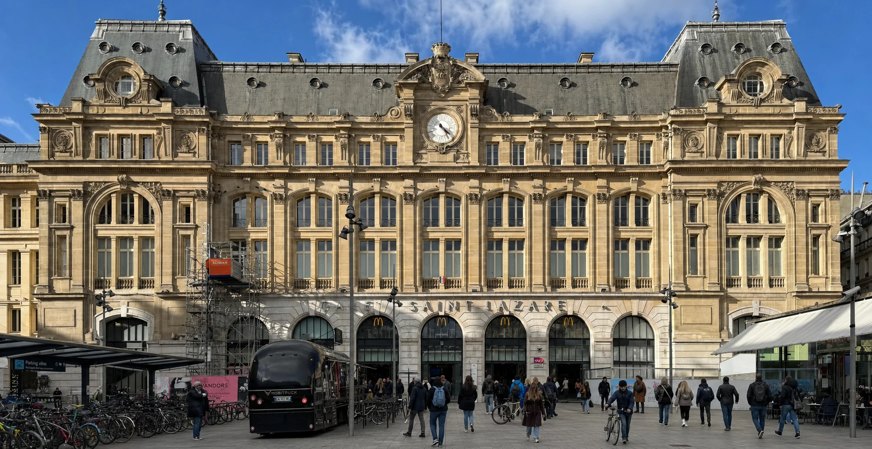 Façade réelle de Paris Saint-Lazare, retouchée avec des voyageurs à vélo entièrement nouveaux