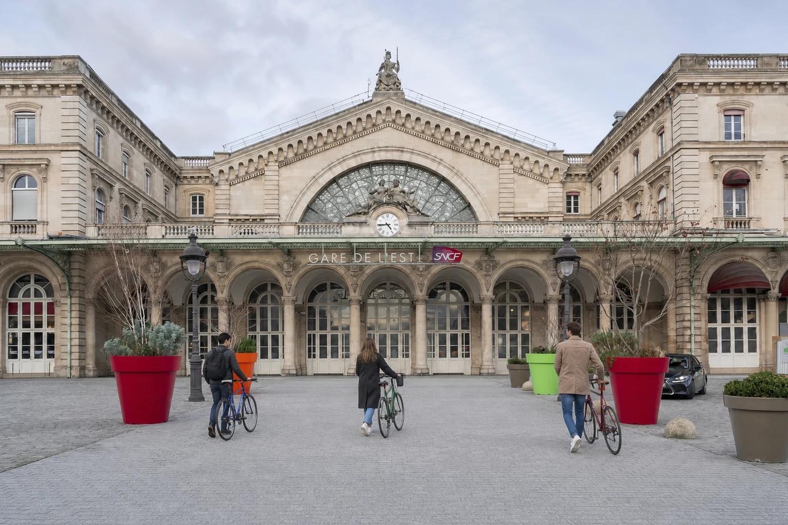 Façade réelle de Paris Gare de l'Est, retouchée avec des voyageurs à vélo entièrement nouveaux